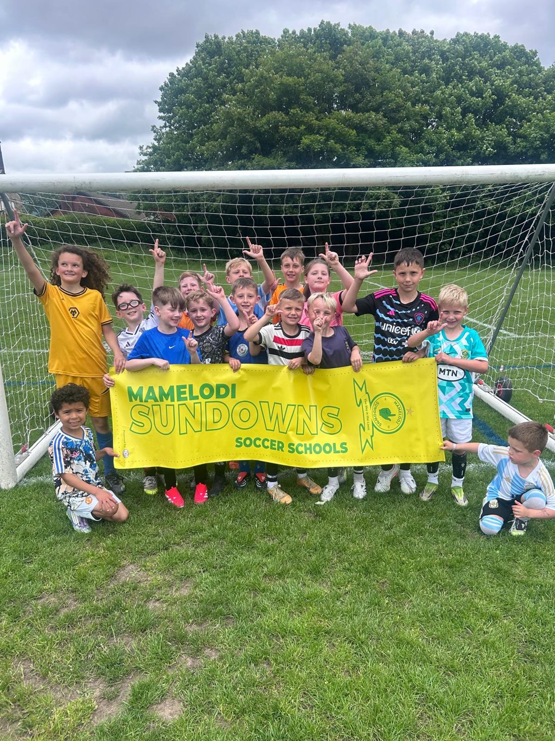 Children gathered with the Sundowns flag
